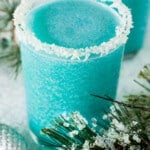 A glass of jack frost cocktail with a coconut crusted rim.