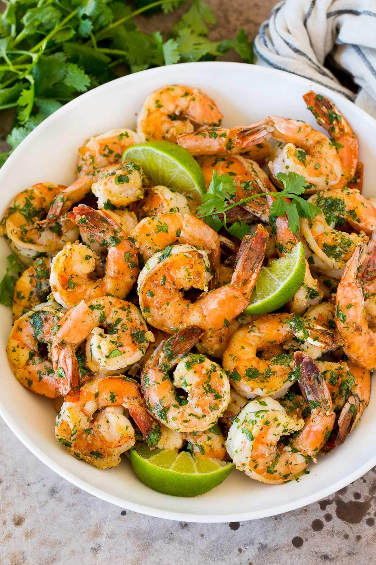 Cilantro Lime Shrimp | Seared Shrimp | Mango Salsa #salsa #shrimp #dinner #appetizer #edsug A serving bowl of cilantro lime shrimp with lime wedges in it.