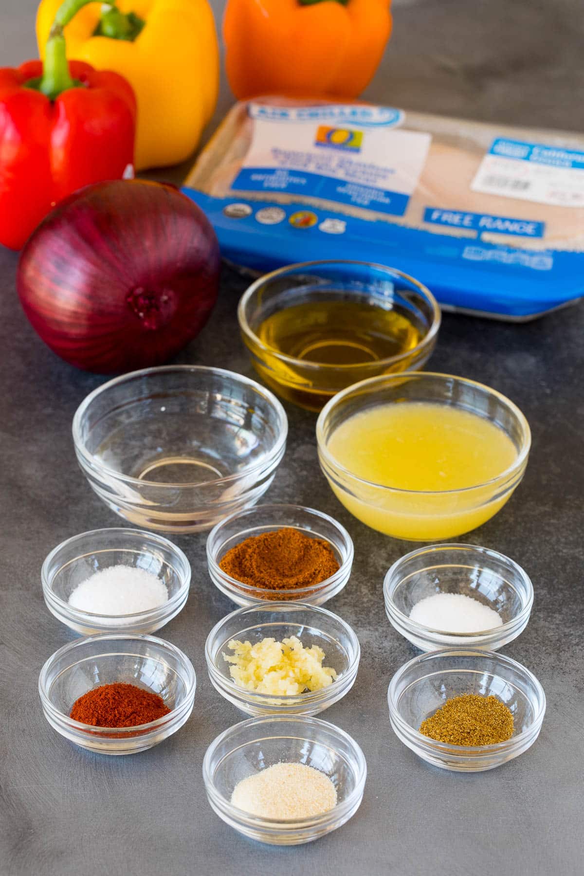 Ingredients including bowls of olive oil, lime juice, spices and chicken.