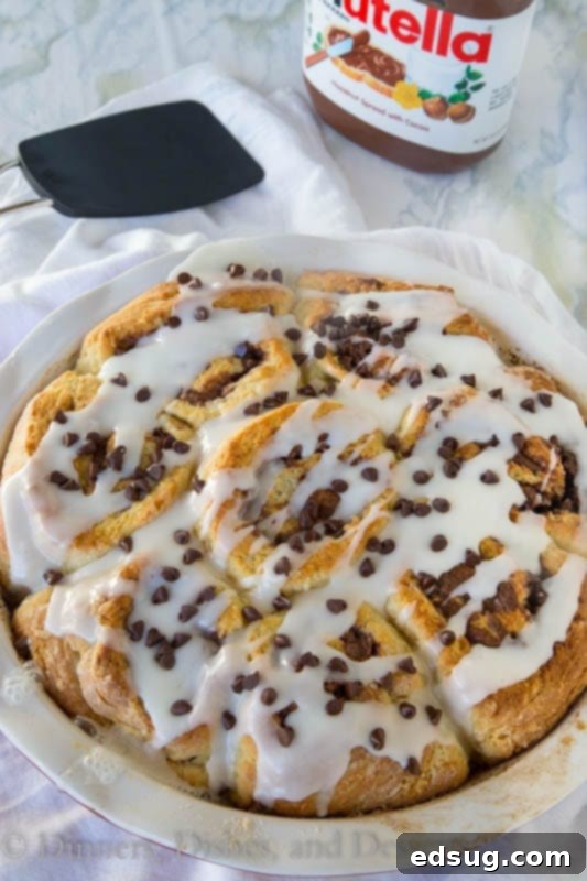 Close-up of baked Nutella cinnamon rolls in a pan, showing their soft, fluffy texture.