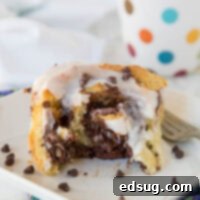 Nutella cinnamon rolls on a plate, topped with a luscious white icing.