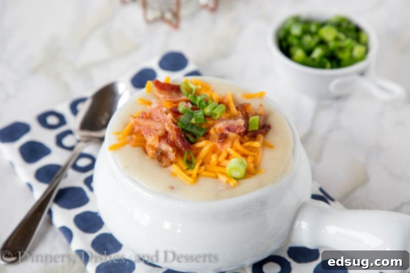 Close-up of potato soup in a bowl with melted cheese and fresh green onions