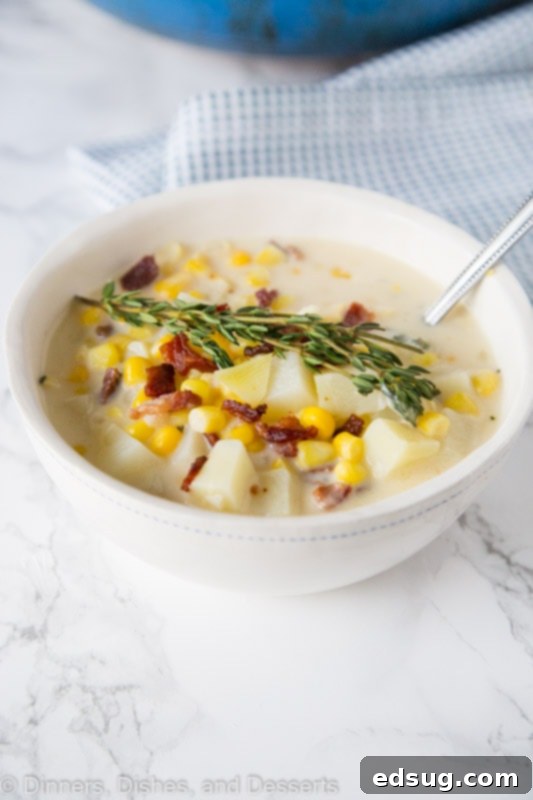 Close-up shot of creamy corn chowder soup with visible corn kernels and potato chunks.