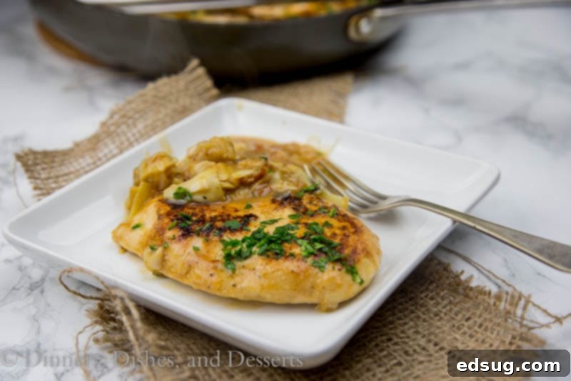Close-up of golden brown chicken breasts in rich artichoke sauce
