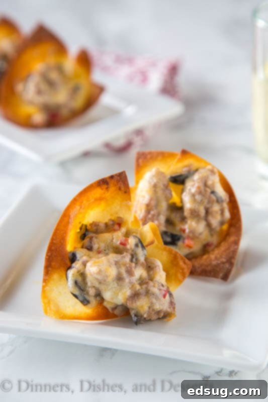 A close up of delicious cheesy sausage wonton cups, baked to golden perfection with a bubbly filling, served fresh.