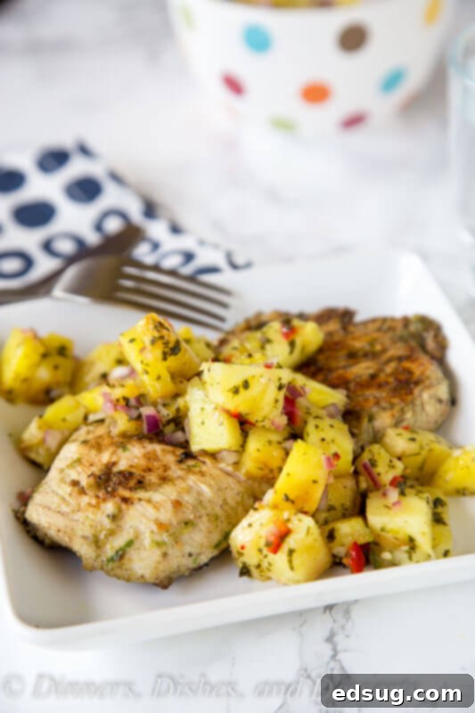 Close-up of grilled Jerk Chicken with vibrant Pineapple Salsa, showcasing fresh ingredients.