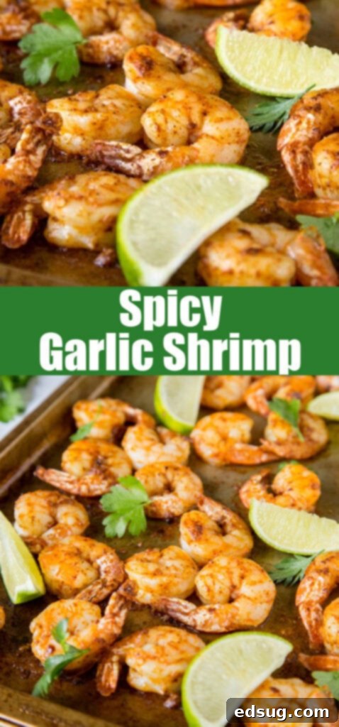 Close up view of spicy garlic shrimp on a sheet pan with lime wedges, highlighting the delicious seasoning