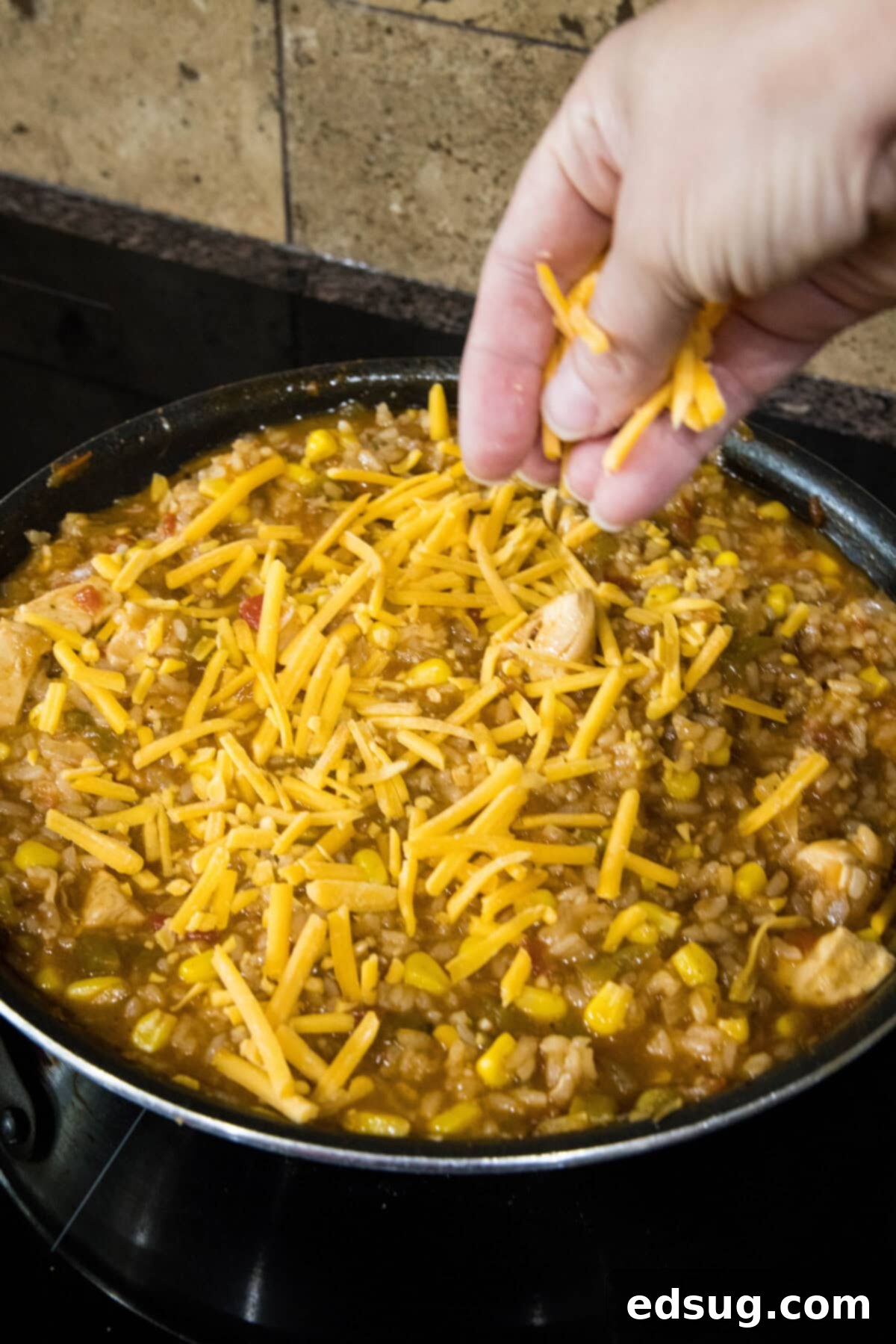 sprinkling cheese over rice skillet