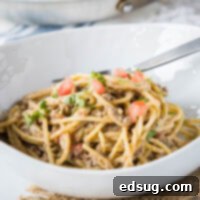 Close up of a white bowl filled with creamy Taco Spaghetti, ready to be enjoyed.