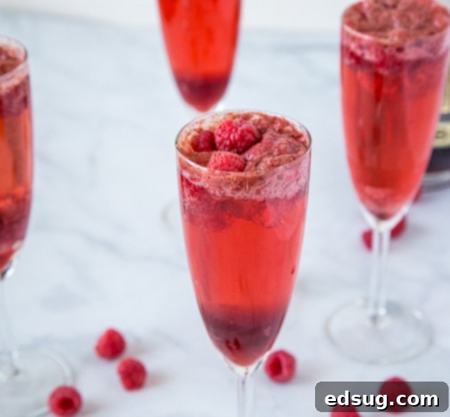 Raspberry Mimosas, a delicious cocktail with raspberry sorbet, champagne, and fresh raspberries.