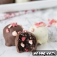 Peppermint Oreo Truffles, small chocolate balls with bits of peppermint, on a white background.