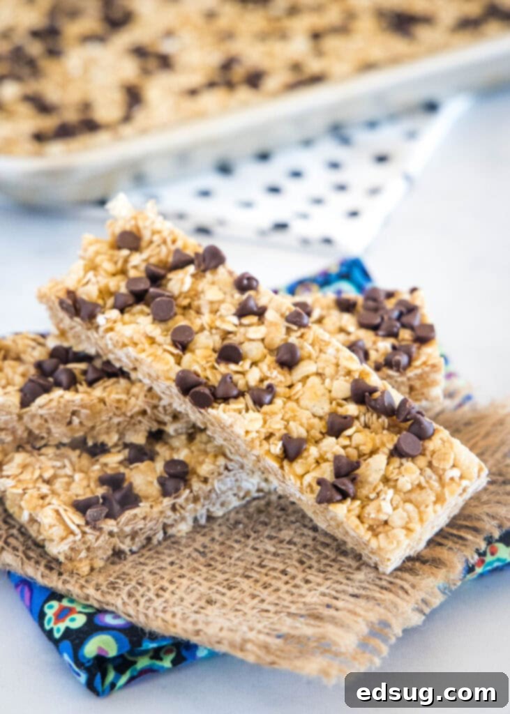 Stacked chewy granola bars on a white napkin, highlighting their golden-brown color and chocolate chips.