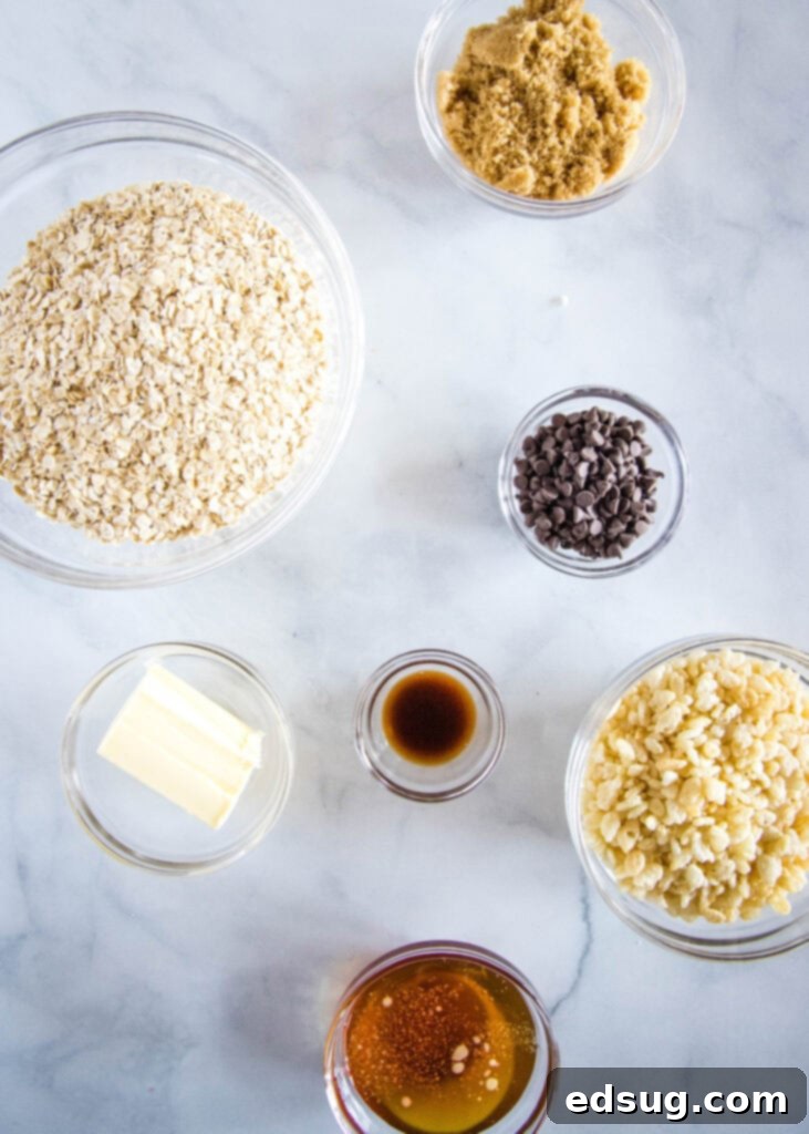 All the dry and wet ingredients for chewy granola bars laid out on a white surface.