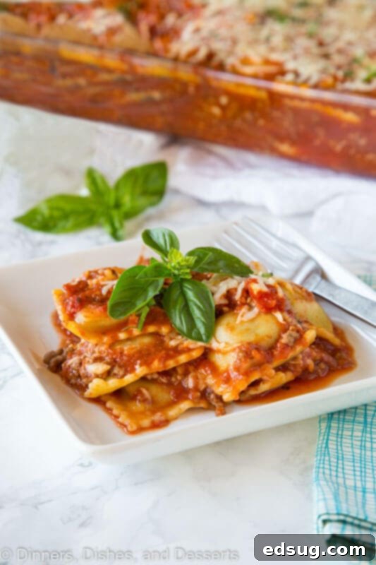 A close-up of a single serving plate of baked ravioli garnished with fresh basil leaves