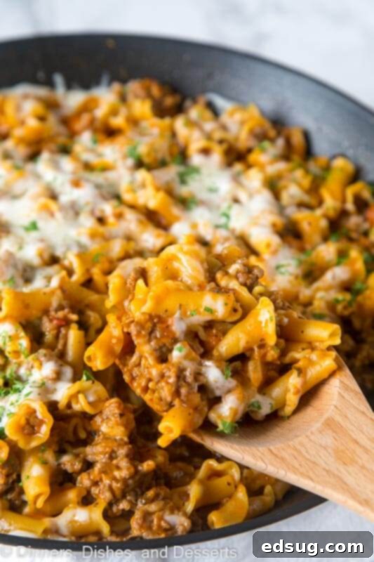 A large serving dish filled with Homemade Hamburger Helper Lasagna featuring Italian sausage and melted cheese.