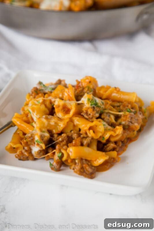 A plate of savory homemade Hamburger Helper Lasagna, garnished with vibrant fresh basil leaves, ready to be enjoyed.