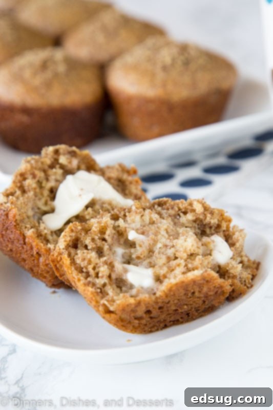 Warm bran muffin on a white plate with melting butter