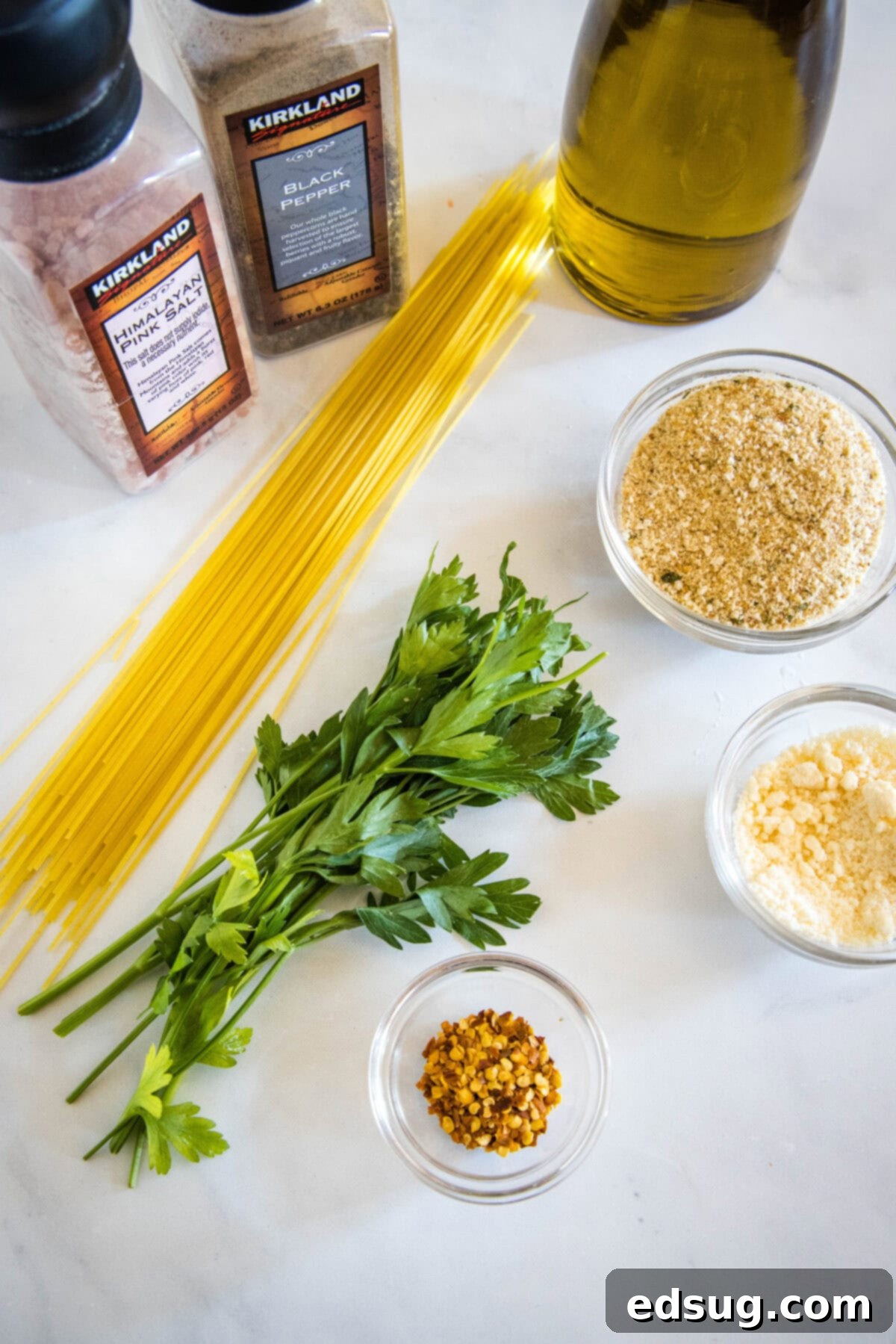Golden Garlicky Crumb Pasta 2 Essential ingredients for pasta with breadcrumbs laid out: spaghetti, olive oil, garlic, red pepper flakes, breadcrumbs, Parmesan, and parsley.