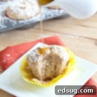 A French toast muffin drizzled with syrup and powdered sugar on a plate