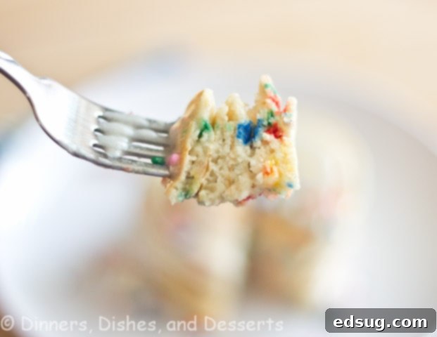 A fork taking a bite of funfetti pancakes, showing the colorful sprinkles inside
