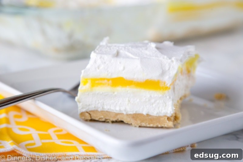 A wider shot of the lemon lasagna dessert, showing multiple slices arranged on a serving platter, invitingly displaying the layers.