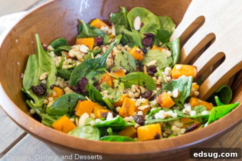 A beautifully composed bowl of Fall Israeli Couscous Salad on a rustic wooden table.