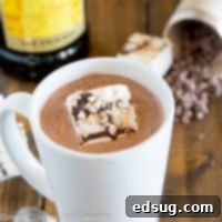 A cup of spiked hot chocolate on a table with marshmallows