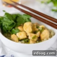 A circular image of a bowl of chicken curry garnished with fresh cilantro, a delicious Thai Green Curry Chicken dish.