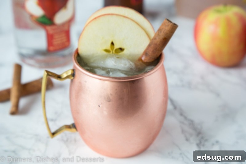 A glass of Apple Cider Moscow Mule garnished with thin apple slices