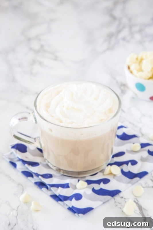 A cup of coffee on a table, with White chocolate and Milk