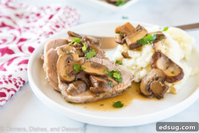 A cutting board with perfectly sliced Instant Pot Pork Tenderloin and a small bowl of the rich mushroom sauce, ready for serving alongside complementary dishes.