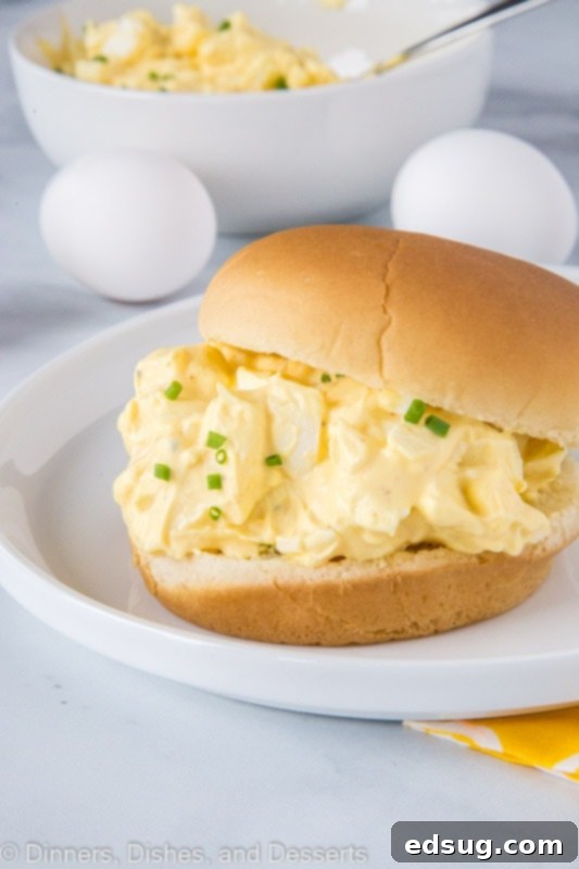 A delicious classic egg salad sandwich on a white plate, ready to be enjoyed