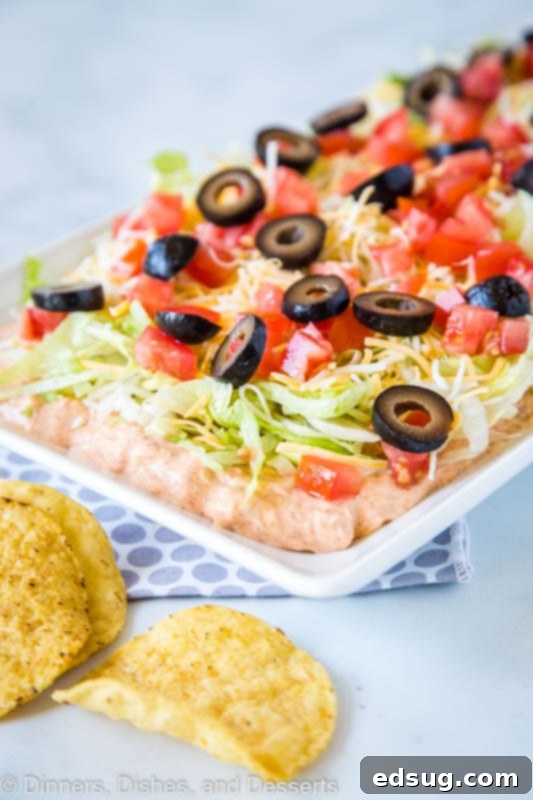 Layered Taco Dip with fresh toppings, perfect for game day or a quick and easy appetizer