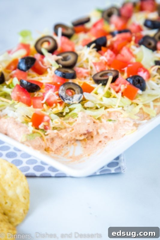 The best taco dip for any get-together! Creamy, spicy, and delicious on a serving platter.