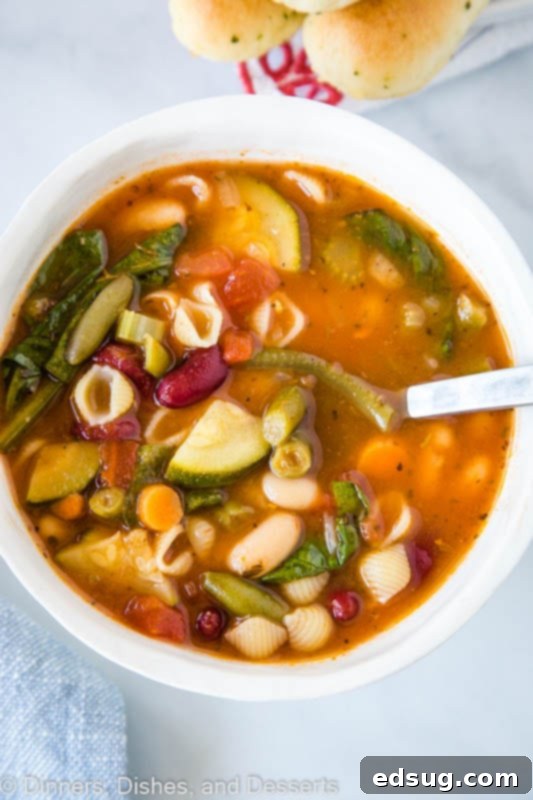 Olive Garden's Hearty Minestrone Soup 2 A hearty bowl of homemade Olive Garden Minestrone Soup with shell pasta, rich tomato broth, and various colorful vegetables, ready to be enjoyed.