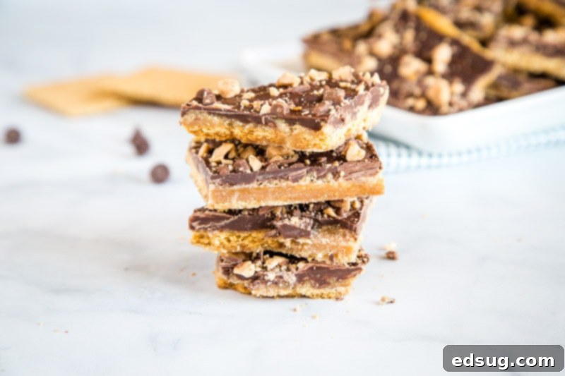 Quick Graham Cracker Toffee Recipe 4 Various pieces of Graham Cracker Toffee with different toppings like sprinkles, toffee bits, and nuts, arranged on a rustic wooden board for a holiday gathering.