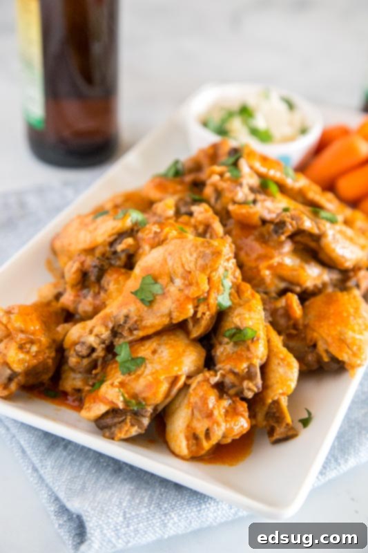 Instant Pot Chicken Wings with buffalo sauce, garnished with parsley, a perfect game day appetizer