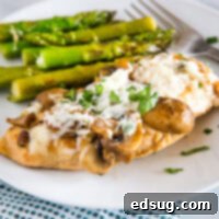 A plate of perfectly cooked Chicken Madeira with tender asparagus, an elegant restaurant-quality meal.