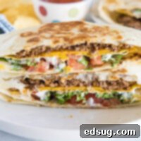 A close-up of a perfectly grilled and folded Crunchwrap Supreme, showing its layers of goodness.