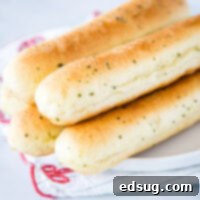 A close-up of fluffy, buttery Olive Garden Breadsticks, ready for dipping.