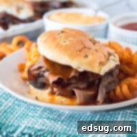 A close-up of a delicious Arby's Beef & Cheddar sandwich with melted cheese and roast beef.