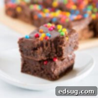 Cosmic Brownies – a homemade version of the childhood favorite. Rich and fudgy brownies topped with a chocolate fudge frosting and rainbow sprinkles.