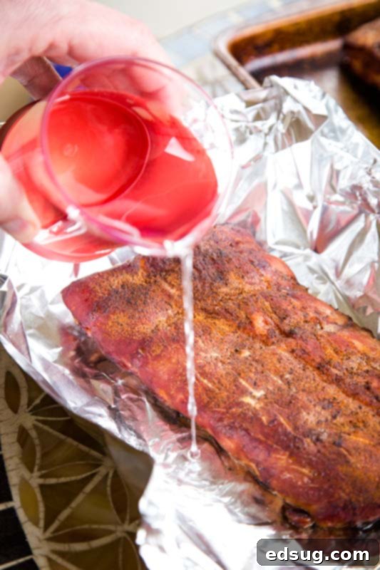 Slow-Smoked Baby Back Ribs 4 Foil wrapping ribs with liquid