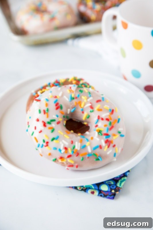 Delicious raised donuts with classic white icing and colorful sprinkles, ready to be enjoyed