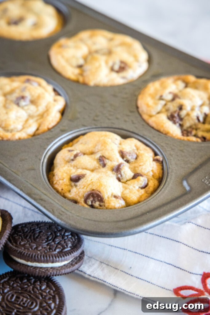 Chocolate Chip Cookies with an Oreo Center 3 A single baked Oreo stuffed chocolate chip cookie nestled in a greased muffin tin.