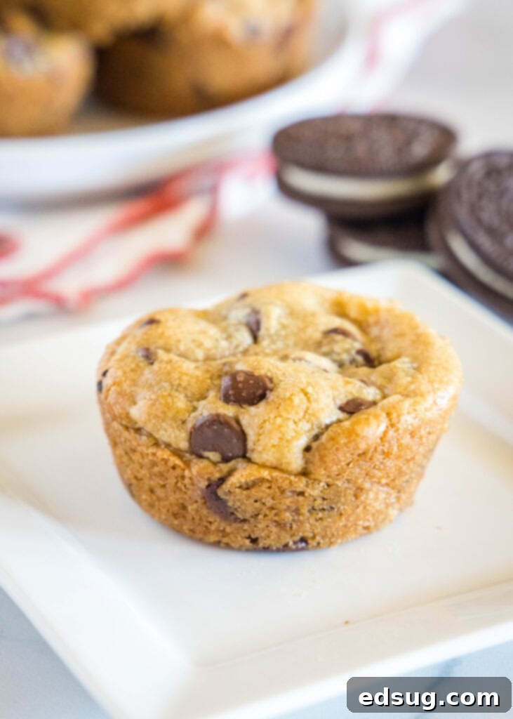 Chocolate Chip Cookies with an Oreo Center 6 A perfectly baked Oreo stuffed chocolate chip cookie with a bite taken out, resting on a white plate.