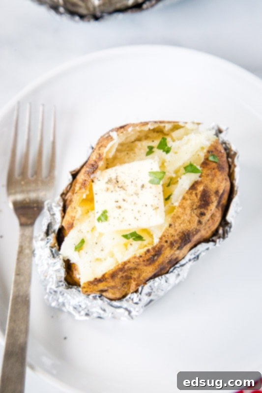 cut open baked potato with butter and chives
