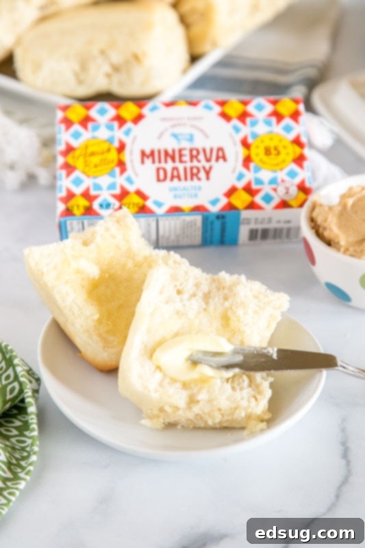roll cut in half with butter being spread on it