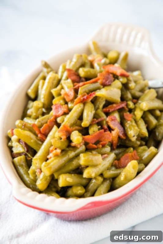 Close-up of perfectly cooked green beans with crispy bacon bits and sautéed onions