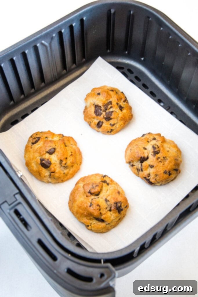 A close-up of air fryer chocolate chip cookies, golden brown and perfectly baked, on parchment paper.